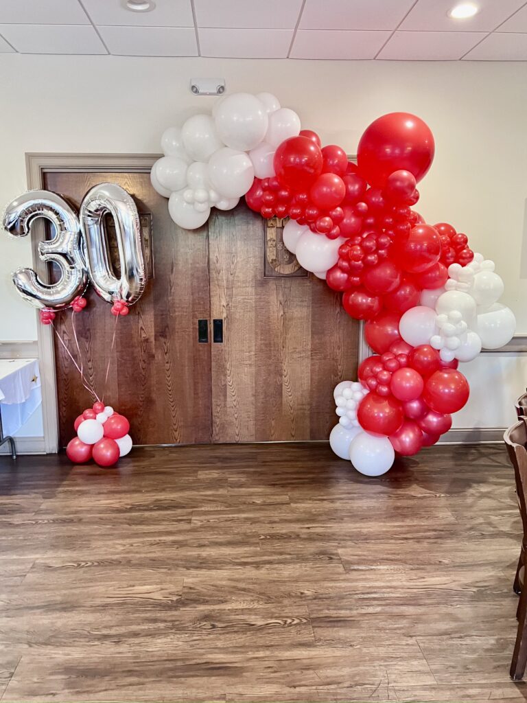 Celebrate 30 years with a white and red balloon garland